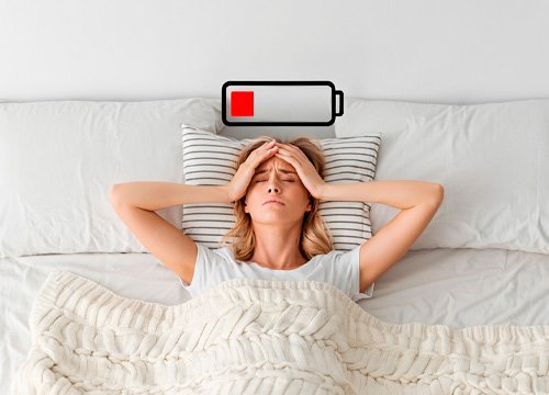 Девушка страдает усталостью Девушка лежит в кровати